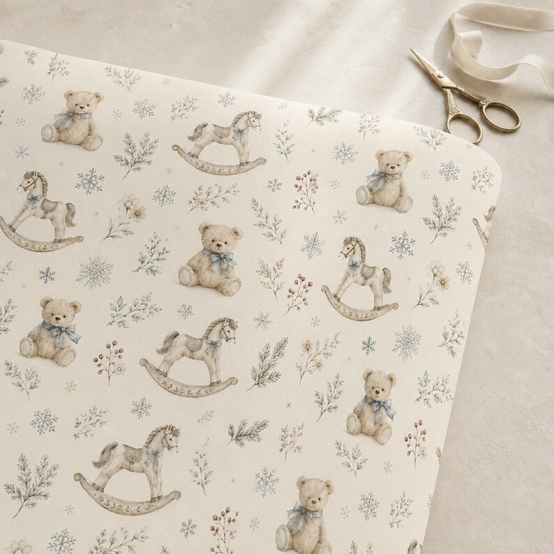 May include: A cream-coloured fabric featuring a repeating pattern of light brown teddy bears with blue bows, rocking horses, snowflakes, and sprigs of foliage. A pair of metal scissors with a ribbon is positioned near the top right corner.
