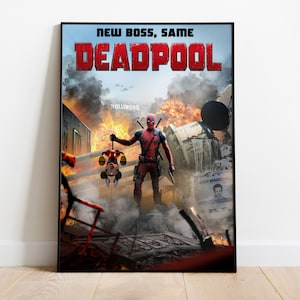 May include: A framed movie poster for Deadpool. The poster features the text "NEW BOSS, SAME DEADPOOL" in red letters. The image shows Deadpool standing in a destroyed area, holding a Mickey Mouse doll. Explosions and a Hollywood sign are in the background.