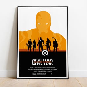 May include: A framed poster featuring a minimalist design for "Captain America: Civil War." The poster has a black border and a color scheme of orange, black, and white. Silhouettes of characters are in the foreground, with a large orange figure in the background.