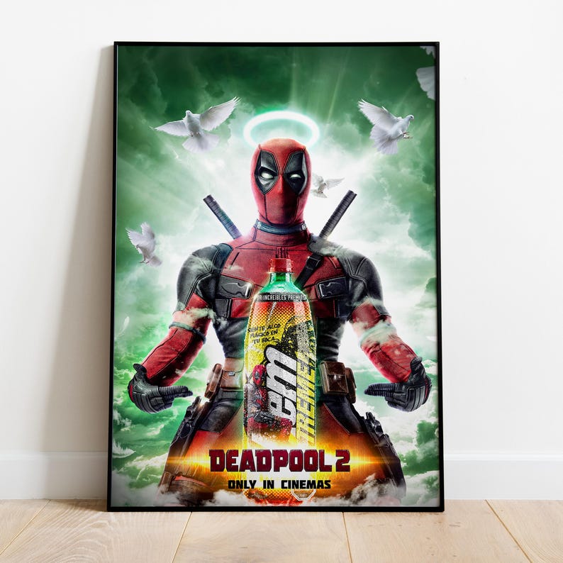 May include: A framed poster featuring Deadpool from Deadpool 2, holding a bottle of a beverage. The poster has a green and orange background with white doves and a halo above Deadpool's head. The text "DEADPOOL 2" and "ONLY IN CINEMAS" are at the bottom.