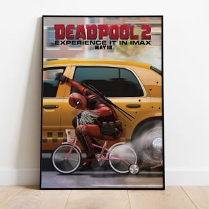 May include: A framed poster for the movie Deadpool 2. The poster features Deadpool riding a pink bicycle next to a yellow taxi cab. The poster's title is in red letters, with the tagline "Experience it in IMAX" and the date "May 18".