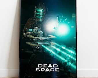 May include: A framed poster featuring a character from the video game "Dead Space." The character is wearing a futuristic suit and helmet, holding a weapon, with a bright green energy effect emanating from the hand and weapon. The words "DEAD SPACE" are printed at the bottom.