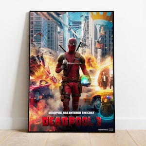 May include: A framed poster featuring Deadpool from Deadpool 3. The image shows Deadpool in his red and black suit, holding a weapon, with a city scene in the background. The poster has the text "DEADPOOL HAS ENTERED THE CHAT" and "DEADPOOL 3".