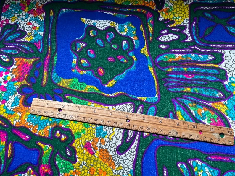 Puede incluir: Una tela colorida con un patr&oacute;n geom&eacute;trico en tonos de verde, azul, amarillo, rosa y blanco. El patr&oacute;n presenta una serie de cuadrados y c&iacute;rculos con una apariencia texturizada, casi como un mosaico.