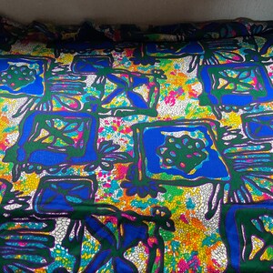 Puede incluir: Una tela colorida con un patr&oacute;n geom&eacute;trico en tonos de azul, verde, amarillo y blanco. El patr&oacute;n presenta formas y l&iacute;neas abstractas.
