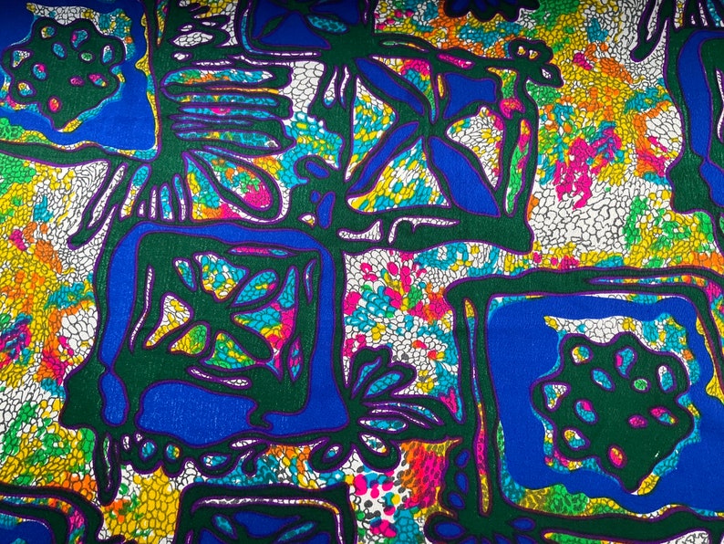 Puede incluir: Tela abstracta con fondo blanco y un patr&oacute;n colorido de verde, azul, morado y amarillo. El patr&oacute;n presenta formas geom&eacute;tricas y dise&ntilde;os florales.