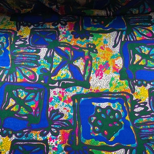 Puede incluir: Tela abstracta con un patr&oacute;n de mosaico colorido. La tela presenta un dise&ntilde;o repetitivo de cuadrados verdes, azules y amarillos sobre un fondo blanco.