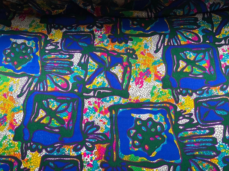 Puede incluir: Tela abstracta con un patr&oacute;n de mosaico colorido. La tela presenta un dise&ntilde;o repetitivo de cuadrados verdes, azules y amarillos sobre un fondo blanco.
