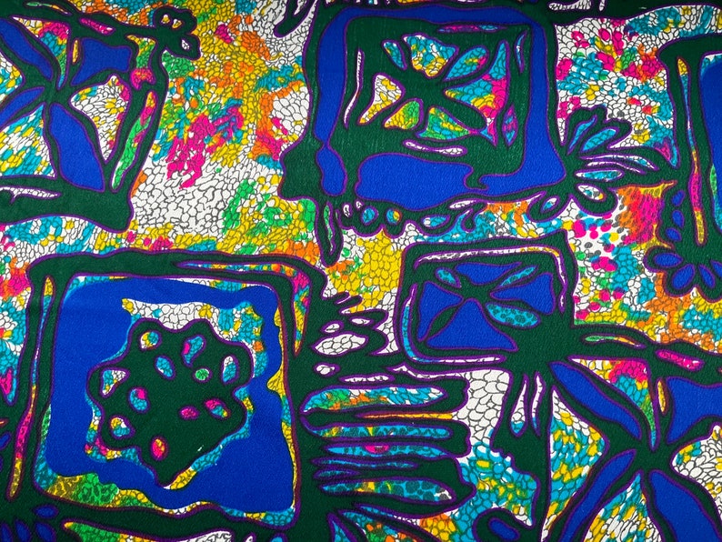 Puede incluir: Tela abstracta con un patr&oacute;n geom&eacute;trico colorido. El dise&ntilde;o presenta formas verdes, azules, moradas, amarillas y blancas sobre un fondo blanco.