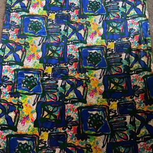 Puede incluir: Una tela colorida con un patr&oacute;n repetitivo de cuadrados azules, verdes y amarillos. Los cuadrados est&aacute;n llenos de dise&ntilde;os abstractos y se colocan sobre un fondo blanco.
