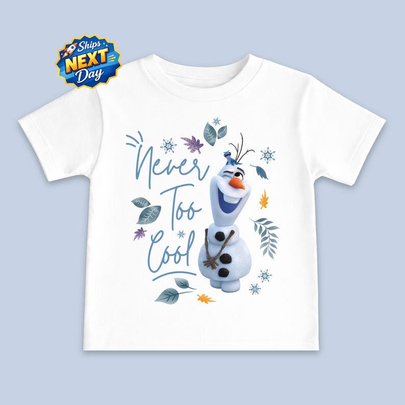 A white t-shirt with a graphic design featuring the character Olaf from the Disney movie Frozen. The design includes Olaf holding a snowflake and surrounded by snowflakes and leaves. The text on the t-shirt says "Never Too Cool".