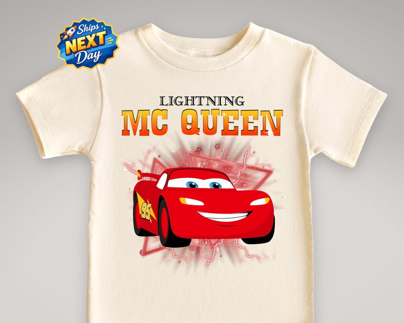 A white t-shirt with a graphic design featuring a red car with the character Lightning McQueen on it.