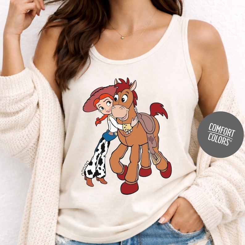 A woman wearing a white tank top with a cartoon image of a girl and a horse printed on it.
