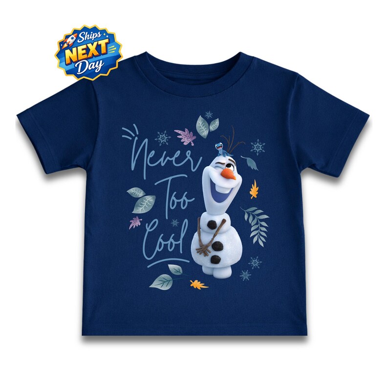 A navy blue t-shirt with a graphic design featuring a smiling snowman character and the text "Never Too Cool" written above it.