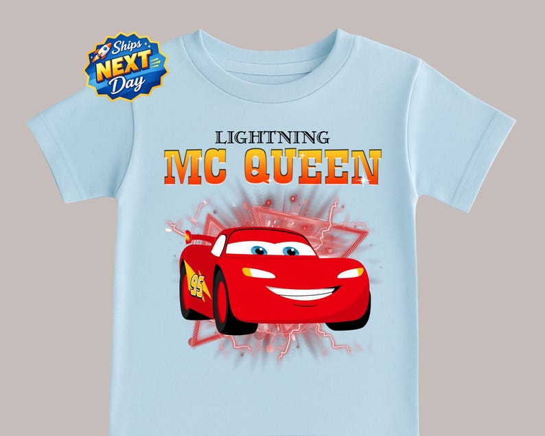 A light blue t-shirt with a graphic of a red car and the text "Lightning MC Queen" printed on it.