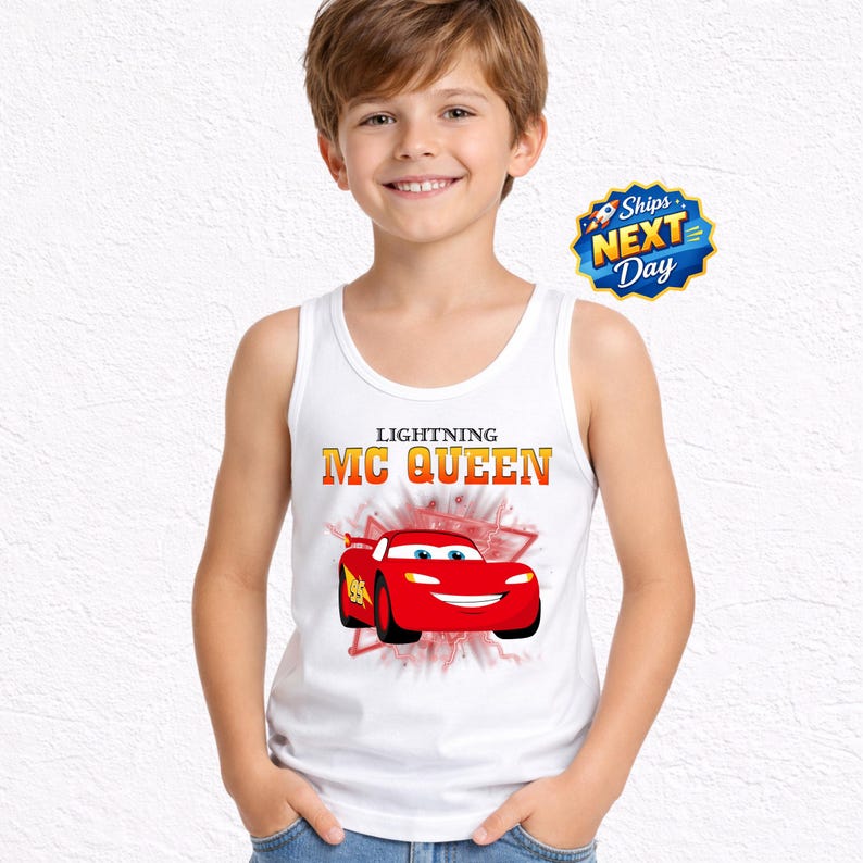 A young boy wearing a white tank top with a graphic of Lightning McQueen from the Cars movie.