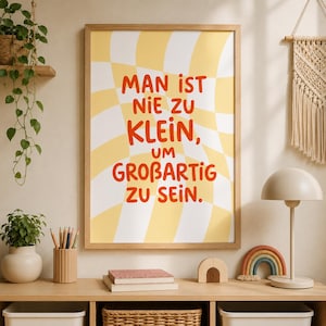 Könnte beinhalten: Ein rechteckiges Wandbild in einem hellen Holzrahmen mit einem gewellten gelb-weißen Schachbrettmuster-Hintergrund und dem orangefarbenen Text "MAN IST NIE ZU KLEIN, UM GROßARTIG ZU SEIN." in einer fetten, abgerundeten serifenlosen Schrift.