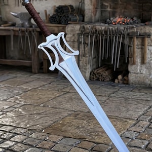 May include: A double-edged sword with a polished silver-toned metal blade and a complex, open-work crossguard. The handle is wrapped in dark brown leather, featuring a rounded metal pommel at the base of the grip, standing upright.