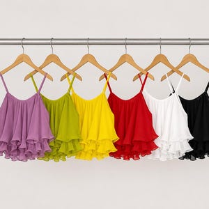 May include: A row of six ruffled camisole tops in various colors, including purple, green, yellow, red, white, and black, hanging on wooden hangers. The tops have thin straps and a layered, flowing design.