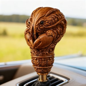 Puede incluir: Un pomo de cambio de madera detallado tallado en forma de langosta. El pomo presenta intrincadas tallas de la cabeza, las pinzas y el cuerpo de la langosta. La base tiene diseños florales ornamentados. El pomo está montado sobre un eje metálico dorado.