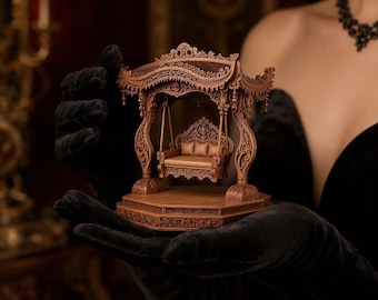 Puede incluir: Un columpio de madera en miniatura con intrincadas tallas, que presenta un dosel detallado y un asiento acolchado. El columpio es de color marrón cálido y se asienta sobre una plataforma de madera. La imagen está sobre un fondo oscuro.