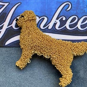May include: A golden retriever dog made of small gold beads. The dog is standing on all four legs with its head turned to the left. The dog is a detailed and realistic representation of a golden retriever.