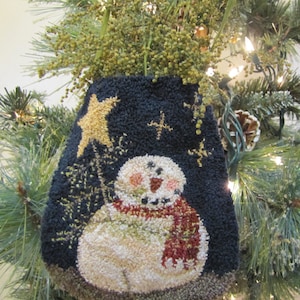 May include: A blue felt stocking with a white snowman and a gold star. The stocking is decorated with a red scarf and a white background.
