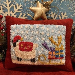 May include: A white sheep wearing a red Santa hat and a red and white sweater pulls a blue sled with a reindeer on it. The sled is filled with presents wrapped in blue, yellow, and purple paper. The background is a blue and white snowy scene.