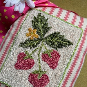 May include: A hand-stitched needlepoint pillow featuring a strawberry design. The pillow is made with a white and pink striped fabric and has a green leaf and yellow flower.