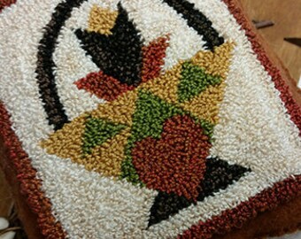 May include: A hand-stitched rug hooking with a colorful floral design in a basket. The rug is made with wool yarn and has a brown background.