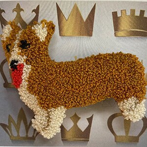 May include: A brown and white plush toy shaped like a corgi dog. The toy has a red nose and black eyes.