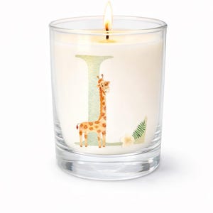 May include: A lit candle in a clear glass jar. The candle has a giraffe illustration with the letter "L" and a fern. The giraffe is brown and orange with a long neck. The candle is white.