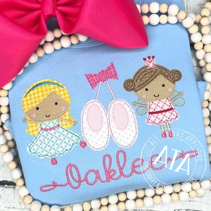 Könnte beinhalten: Hellblaues Baby-Body mit gesticktem Ballett-Design. Zeigt eine Ballerina, Ballettschuhe und eine Fee. Der Name "Oakley" ist in rosa Schrift gestickt. Oben befindet sich eine große rosa Schleife.