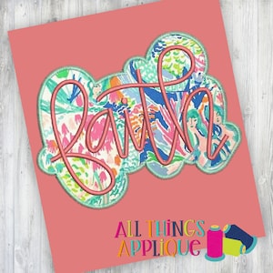 May include: A pink and green floral fabric applique with the word "Faith" embroidered in a pink cursive font.