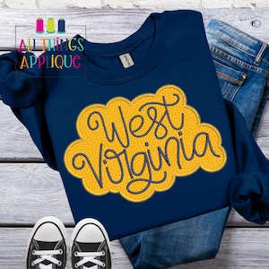 Op de afbeelding: Een marineblauw sweatshirt met een geborduurd ontwerp in geel en marineblauw met de tekst "West Virginia" in de vorm van een wolk.