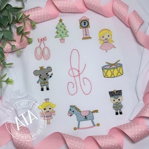 May include: Embroidered design featuring a Nutcracker theme with a Christmas tree, a clock, a drum, a rocking horse, a ballerina, a mouse, a nutcracker soldier, and the letter J.