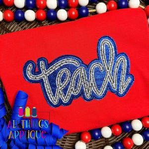 May include: Red shirt with a blue and silver glitter "Teach" applique. The applique has a sparkly, textured finish.