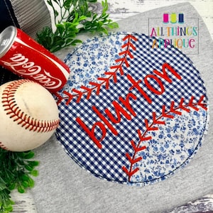 May include: A baseball with red stitching next to a Coca-Cola can and a baseball-themed applique. The applique features a blue and white gingham pattern with the name "Burton" embroidered in red. The text "All Things Applique" is also visible.