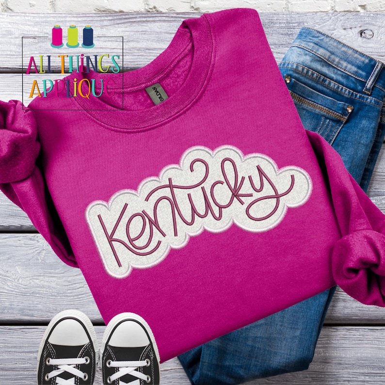 Puede incluir: Una sudadera rosa con un dise&ntilde;o bordado en blanco y rosa que dice "Kentucky".
