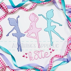 May include: Three ballerina silhouettes in pink, blue, and purple, with the name "kate" embroidered in pink below. The silhouettes are surrounded by pink and blue ribbons.