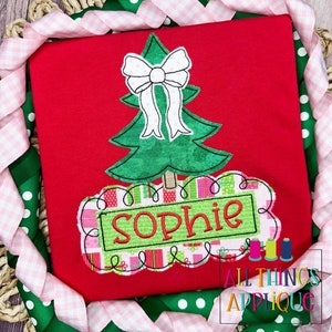 Peut inclure: Appliqué de Noël rouge avec un sapin vert, un nœud blanc et une bannière avec le nom "Sophie" en lettres vertes et rouges.