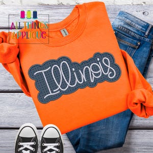 May include: Orange sweatshirt with a blue and white embroidered applique that says "Illinois".