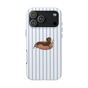 May include: A phone case with a blue and white striped pattern. The case features a cartoon dachshund wearing sunglasses and floating on a pool float with a drink. The phone's camera lenses are visible at the top.