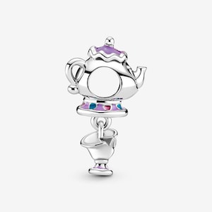 Può includere: Un charm in argento a forma di teiera con coperchio viola e base con accenti in smalto blu e rosa. Una piccola tazza da tè in argento abbinata pende dalla parte inferiore della teiera, che presenta un'apertura circolare per un bracciale.