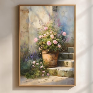 May include: A framed painting depicts a sunlit outdoor scene. A weathered terracotta pot overflows with pink roses and purple flowers. Stone steps lead up to a wall, with soft light and shadows enhancing the scene's depth and texture. The artwork is framed in a light wood.