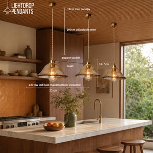 May include: Three pendant lights with amber-tinted glass shades and copper sockets. Each features a 12cm iron canopy, 200cm adjustable wire, and a 25cm wide shade. Includes an E27 4w LED bulb, max 60w, with a 14.5cm height for the glass component.