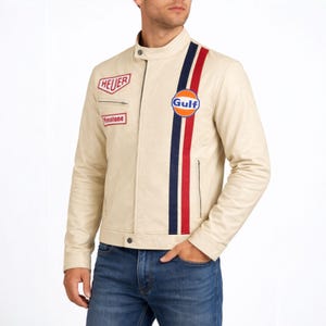 May include: Cream-colored leather jacket with a stand-up collar and a vertical stripe in navy, red, and white. Features the "Gulf" logo and patches for "Heuer" and "Firestone". A classic racing-inspired design.