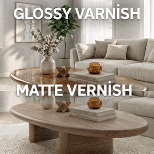 May include: Two oval wooden coffee tables, one with a glossy varnish and the other with a matte finish, are shown in a living room. The tables are surrounded by neutral-toned furniture and decor, including a sofa, vases, and books. The text "GLOSSY VARNISH" and "MATTE VARNISH" are displayed.
