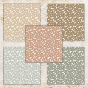 May include: Five square patterned papers with a floral design. The papers feature a variety of neutral colors, including beige, brown, and gray, each with a repeating pattern of small white flowers. The papers are arranged on a light wood surface.