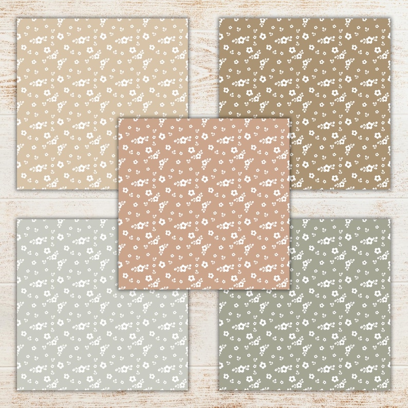 May include: Five square patterned papers with a floral design. The papers feature a variety of neutral colors, including beige, brown, and gray, each with a repeating pattern of small white flowers. The papers are arranged on a light wood surface.